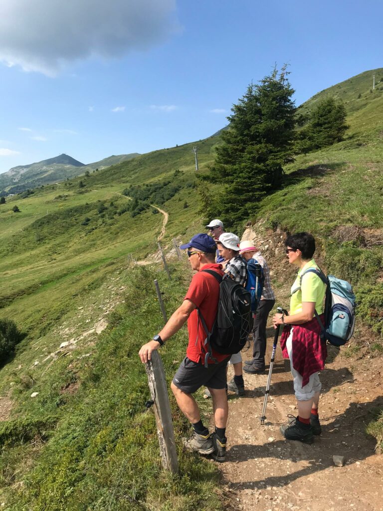 Die Wandergruppe geniesst die herrliche Aussicht Richtung Lenzerheide und Parpaner Rothorn.
