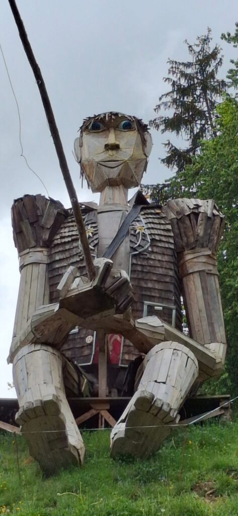 und begrüsst die Wandernden in der traditionellen Fribourger-Tracht. - 04.05.2025