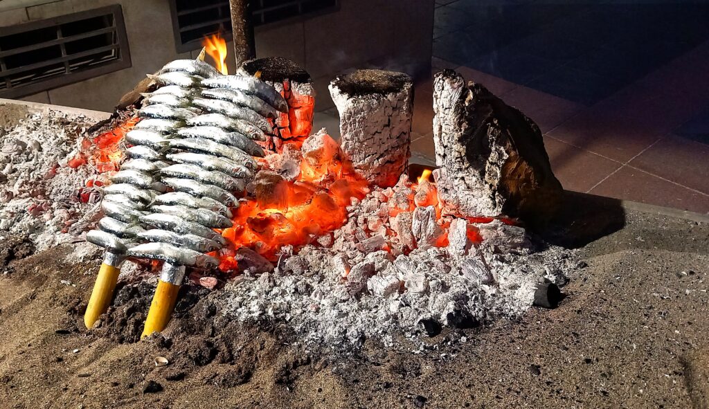Strandpromenade Carihuela: Andalusien ist berühmt für seine einfache, aber raffiniert zubereitete Meeresküche. Der absolute Klassiker für Fisch auf dem Grill sind die Espetos de sardinas – frische Sardinen auf einem Schilfrohr, die traditionell direkt am Strand über dem offenen Holzfeuer gegrillt werden. - 10.06.2026